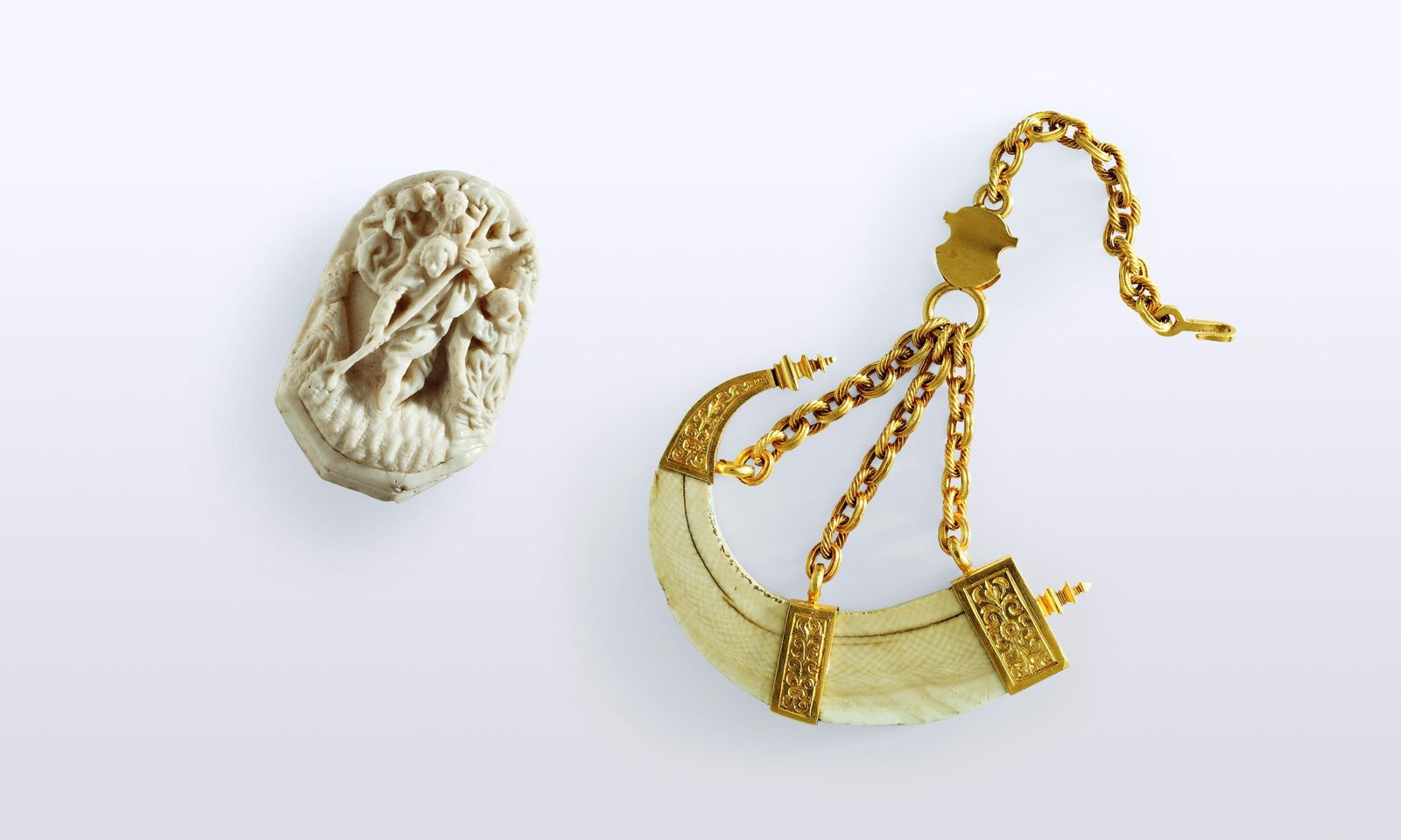 Anhänger in Form eines Pulverhorns aus Elfenbein mit goldener Fassung und dreiteiliger Goldkette. ("Wildschweinzahn")