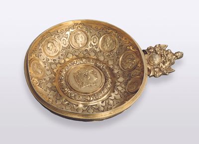 Schale aus vergoldetem Silber mit 11 eingelassenen antiken Münzen. Griff in Gestalt einer fürsorgenden Caritas mit 2 Kindern.