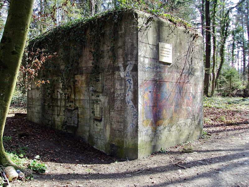 Zitattafel Friedrich Dürrenmatt (1921 - 1990): &quot;In der Wirtschaft geht es nicht gnädiger zu als in der Schlacht im Teutoburger Wald.&quot;
(Im Guggenbühlwald steht ein Bunker aus
dem 2. Weltkrieg. Er war Teil der Festung
Dietikon.)