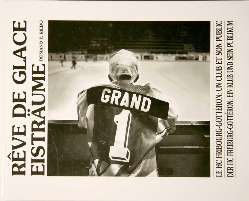 REVE DE GLACE | EISTRÄUMEReportage photographique en noir et blanc sur le phénomène du hockey sur glace et le HC Fribourg Gottéron au moment même où les meilleurs hockeyeurs du monde, le duo russe Bykov et Chomutov, rejoignent par transfert le club qui avait échappé de justesse à la relégation l&#39;année précédente.C&#39;était au début de l&#39;ouverture du &quot;rideau de fer&quot; et souvent, à l&#39;époque, on disait encore „Moscou - aller simple“ quand on voulait se débarrasser de gens aux idées de gauche. C&#39;est alors qu&#39;éclate dans toute la région et dans le hockey sur glace suisse la &quot;fièvre russe&quot; et que les deux professionnels, &quot;magiciens sur la glace&quot;, comme le disait la presse euphorique, catapultent le petit club régional en tête de la ligue - et plusieurs fois de suite en finale.Publié sous forme de livre en 1995 (préface de Charles-Henri Favrod, directeur du Musée de l&#39;Elysée, Lausanne) et présenté au Musée de Tavel, ce travail constitue aujourd&#39;hui un document artistique et sociologique unique, un jalon dans la photographie sportive suisse, le témoignage d&#39;une époque à l&#39;aube du phénomène du sport de masse.EISTRÄUME | REVE DE GLACEFotoreportage in Schwarz-Weiss über das Phänomen Eishockey und den HC Fribourg Gottéron just zu jenem Zeitpunkt, als mit dem russischen Duo Slava Bykov und Andrei Khomutov die besten Eishockeyspieler der Welt per Transfer zum Verein stossen, der im Jahr davor nur ganz knapp dem Abstieg entgangen war.Das war zu Beginn der Öffnung des „eisernen Vorhangs“ und oft hiess es damals noch „Moskau einfach“, wenn man Leute mit linken Vorstellungen loswerden wollte. Dann bricht in der ganzen Region und im Schweizer Eishockey das „Russenfieber“ aus und die beiden Profis, „Zauberer auf dem Eis“, wie die nationale Sportpresse euphorisch titelt, katapultieren den kleinen Regionalklub an die Spitze der Liga - und mehrmals hintereinander in den Final.1995 in Buchform veröffentlicht (Vorwort von Charles-Henri Favrod, Direktor Musée de l’Elysée, Lausanne) und im Museum Tafers erstmals gezeigt, stellt diese Arbeit heute ein einzigartiges künstlerisches und zeitgeschichtliches Dokument dar, einen Meilenstein in der Schweizer Sportfotografie, Zeugnis einer Epoche am Anfang des Phänomens Massensport. Denn statt nur die Stars zu fotografieren, richtet der Fotograf sein Objektiv auf die Fans, die Menschen im Hintergrund, den Nachwuchs, die Journalisten und das Publikum.Links:
GALLERY
https://romanoriedo.ch/9_pr-sentation-presentation/52_eistr-ume-reve-de-glaceARCHIVE
https://www.fotopunkt.ch/gallery/Bykov-Gotteron-Co/G0000rdvpNj8k9fs