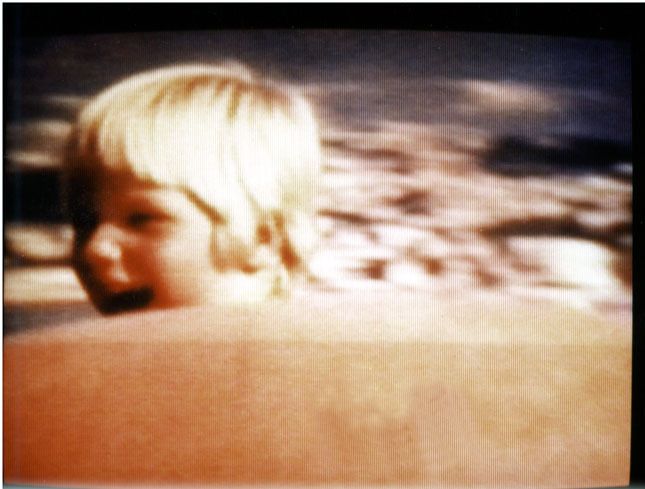 Television: Past, memory, imaginary level. A looped moment of happiness: A laughing child looks over the edge of a red rubber boat. The boat comes closer in slow motion and moves away again. This sequence of about 6 seconds is constantly repeated, creating an eternal rocking.