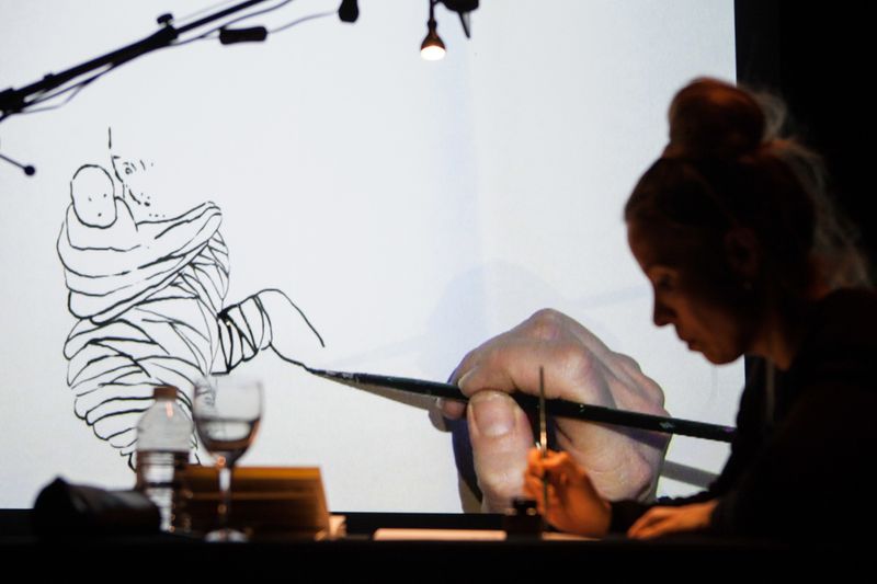 Karoline Schreiber draws while Anders Guggisberg is playing music